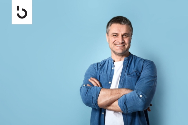 confident man smiling against blue background representing crypto active loans industry